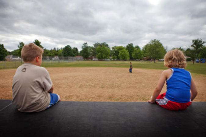2 children looking toward playground equipment